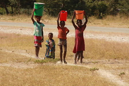 Owambo children carrying water to the homestead