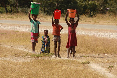 Owambo children carrying water to the homestead